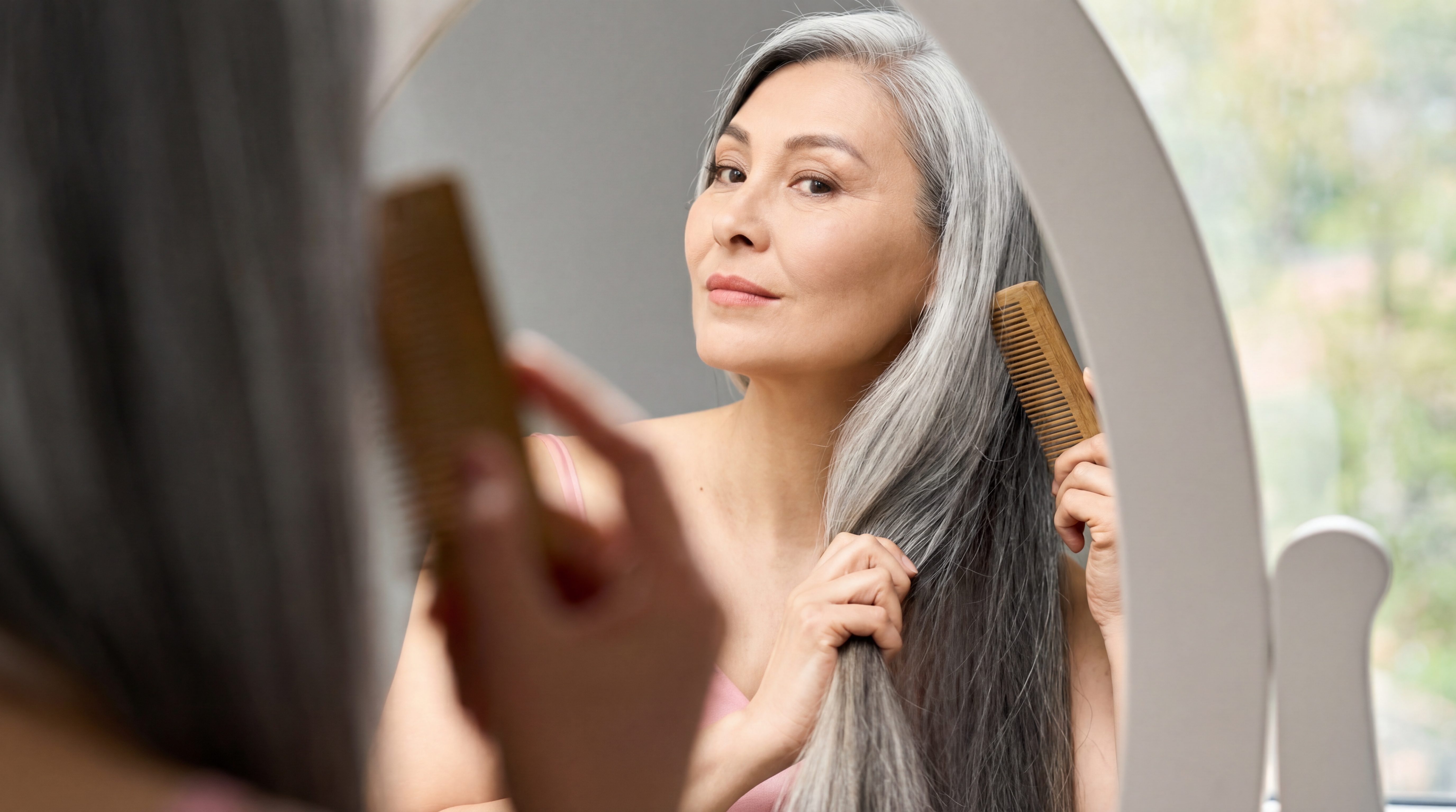 Menopausal woman caring for her hair and wellbeing in front of a mirror